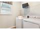 Bright laundry room with washer, dryer, storage shelf, and natural light from the window at 5228 Bee Balm St, Lake Hamilton, FL 33851