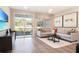 Comfortable living room features a modern sofa, stylish decor, and sliding glass doors that open to the outdoors at 5228 Bee Balm St, Lake Hamilton, FL 33851