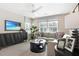 Bright living room featuring a sectional sofa, modern decor, and a wall-mounted flat-screen TV at 5228 Bee Balm St, Lake Hamilton, FL 33851