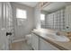 Clean bathroom with a single sink vanity, toilet, and a shower with a black and white checkered curtain at 553 Bailey Cir, Davenport, FL 33897
