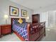 This bedroom features a wooden frame bed, two bedside tables with lamps, and light gray walls at 553 Bailey Cir, Davenport, FL 33897