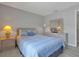Well-lit bedroom featuring a queen-sized bed with blue bedding, a wooden dresser, and soft lighting at 553 Bailey Cir, Davenport, FL 33897