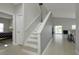 Bright entryway featuring tile floors, stairs with white railings, and an open view to the living area and outdoor scenery at 553 Bailey Cir, Davenport, FL 33897