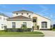 Charming two-story home featuring a well-manicured lawn and arched entryway at 553 Bailey Cir, Davenport, FL 33897