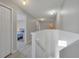 Upstairs hallway with hardwood floors leading to bedrooms, featuring recessed lighting and fresh paint at 553 Bailey Cir, Davenport, FL 33897