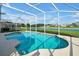 A pristine screened-in pool overlooking a serene waterfront view at 553 Bailey Cir, Davenport, FL 33897