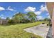The backyard has a concrete patio, green grass, a wooden fence, and beautiful blue skies at 572 Floral Dr, Kissimmee, FL 34743