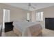 This bedroom features a white ceiling fan, two windows, and a bed with a white comforter at 572 Floral Dr, Kissimmee, FL 34743