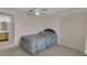 Cozy carpeted bedroom with ceiling fan, large closet, and a view into the bathroom at 572 Floral Dr, Kissimmee, FL 34743