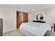 This bedroom features a ceiling fan, closet with wooden doors, and a bed with a white comforter at 572 Floral Dr, Kissimmee, FL 34743