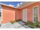 Welcoming front entrance with a security door, decorative plants, and a well-maintained walkway at 572 Floral Dr, Kissimmee, FL 34743