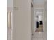 Neutral hallway with tile flooring leading to carpeted bedroom and a peek into the living area at 572 Floral Dr, Kissimmee, FL 34743