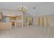 Bright, open-concept living space adjacent to kitchen featuring tile flooring and neutral decor at 572 Floral Dr, Kissimmee, FL 34743