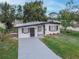 A charming single-story home with modern gray paint, new driveway, and well-maintained lawn at 673 E Church Ave, Longwood, FL 32750