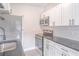 A modern kitchen featuring stainless steel appliances, gray countertop, and white cabinets at 673 E Church Ave, Longwood, FL 32750