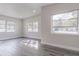 Bright living room with gray wood floors and multiple windows at 673 E Church Ave, Longwood, FL 32750
