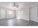 Living room features gray wood flooring, a ceiling fan, and two windows at 673 E Church Ave, Longwood, FL 32750