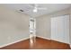 Bright bedroom features hardwood floors, a ceiling fan, and closet storage at 6824 Chaucer Ln, Orlando, FL 32809