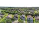 Aerial view of neighborhood with manicured lawns, mature trees, and houses, set near a lake at 707 Stonewyk Way, Kissimmee, FL 34744