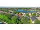 Aerial view of a home in a neighborhood close to a lake and surrounded by lush trees at 707 Stonewyk Way, Kissimmee, FL 34744