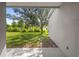 Covered back porch view of the large backyard and mature shade tree, perfect for outdoor enjoyment at 707 Stonewyk Way, Kissimmee, FL 34744