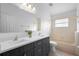 Bright bathroom featuring a dual sink vanity with dark cabinets and a bathtub and shower combination at 707 Stonewyk Way, Kissimmee, FL 34744