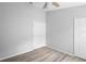 Bedroom with neutral walls, wood-look floors, and ceiling fan, featuring a closet for storage at 707 Stonewyk Way, Kissimmee, FL 34744