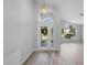 Bright foyer featuring wood flooring, a decorative front door, and an arched window above the doorway at 707 Stonewyk Way, Kissimmee, FL 34744