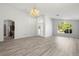 Open living area with vaulted ceilings, wood flooring, and an elegant chandelier at 707 Stonewyk Way, Kissimmee, FL 34744