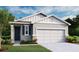 Charming single-story home featuring a two-car garage, craftsman-style details, and a welcoming front yard at 749 Lake Dell Ave, Dundee, FL 33838