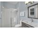 Modern bathroom featuring a walk-in shower with glass door, neutral tiling, and a stylish vanity at 7745 Comrow St, Kissimmee, FL 34747