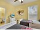 Bedroom with two twin beds, a flat-screen tv, bright yellow walls and adjacent bath area at 7745 Comrow St, Kissimmee, FL 34747