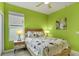 Bright green bedroom featuring a ceiling fan, natural light, and modern decor at 7745 Comrow St, Kissimmee, FL 34747