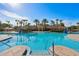 Enjoy the community pool with various seating areas, tropical palm trees, and an inviting atmosphere at 7745 Comrow St, Kissimmee, FL 34747