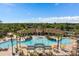 Expansive community pool with palm trees, umbrellas, lounge chairs, and a clubhouse for relaxation and socializing at 7745 Comrow St, Kissimmee, FL 34747