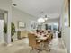 Bright dining room has a light wood table and chairs, an open living space, and light hardwood floors at 7745 Comrow St, Kissimmee, FL 34747