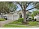 Single-story home with a two car garage, well-manicured lawn, and lush landscaping at 7745 Comrow St, Kissimmee, FL 34747