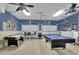 Spacious game room area with a pool table, air hockey table, and high ceilings at 7745 Comrow St, Kissimmee, FL 34747
