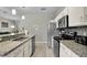 Well-equipped kitchen features stainless appliances, granite countertops, and light wood floors at 7745 Comrow St, Kissimmee, FL 34747
