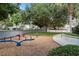 Community playground with seesaws, swings, and play structures in a wooded setting at 7745 Comrow St, Kissimmee, FL 34747