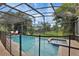 Inviting screened-in pool and spa area surrounded by brick pavers and lush landscaping at 7745 Comrow St, Kissimmee, FL 34747