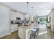 Bright open-concept kitchen with white cabinetry, stainless steel appliances, and a large island with bar seating at 811 Lake Dell Rd, Dundee, FL 33838