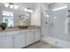 A bathroom featuring double sinks, a shower with glass doors and neutral tiling at 811 Lake Dell Rd, Dundee, FL 33838
