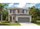 Charming two-story home featuring a neutral color scheme, attached garage, and well-manicured lawn at 819 Lake Dell Rd, Dundee, FL 33838