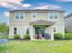 A covered patio complements the rear exterior of this two-story home with a well-manicured yard at 8635 Tallfield Ave, Orlando, FL 32832