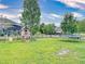 The backyard features a well-maintained lawn, a playground, a trampoline, and secure black metal fencing at 8635 Tallfield Ave, Orlando, FL 32832