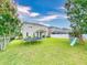 Spacious backyard featuring a well-maintained lawn, trampoline, play set, and a covered patio at 8635 Tallfield Ave, Orlando, FL 32832