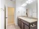 Primary bathroom featuring double sinks, dark cabinetry, and granite countertops at 8635 Tallfield Ave, Orlando, FL 32832