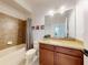Bathroom featuring a vanity with granite countertop and a shower over tub tiled to the ceiling at 8635 Tallfield Ave, Orlando, FL 32832