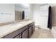 Bathroom featuring double sinks, dark cabinetry, and granite countertops at 8635 Tallfield Ave, Orlando, FL 32832